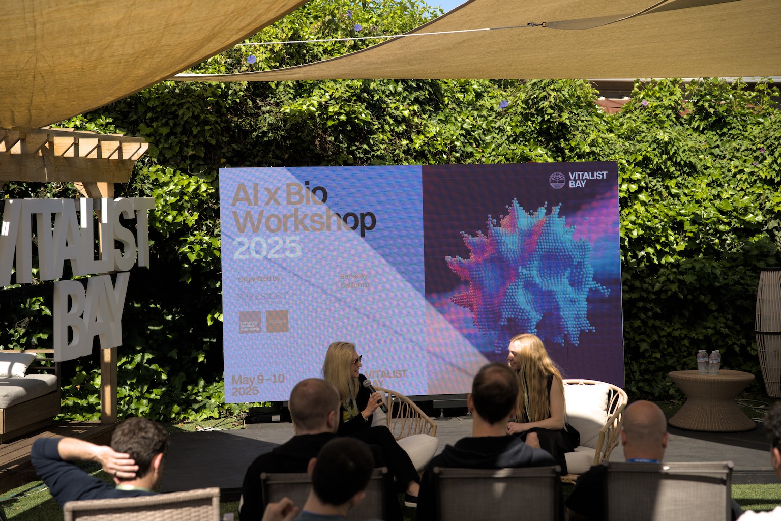 AI × Bio Workshop stage screen, on-site photo