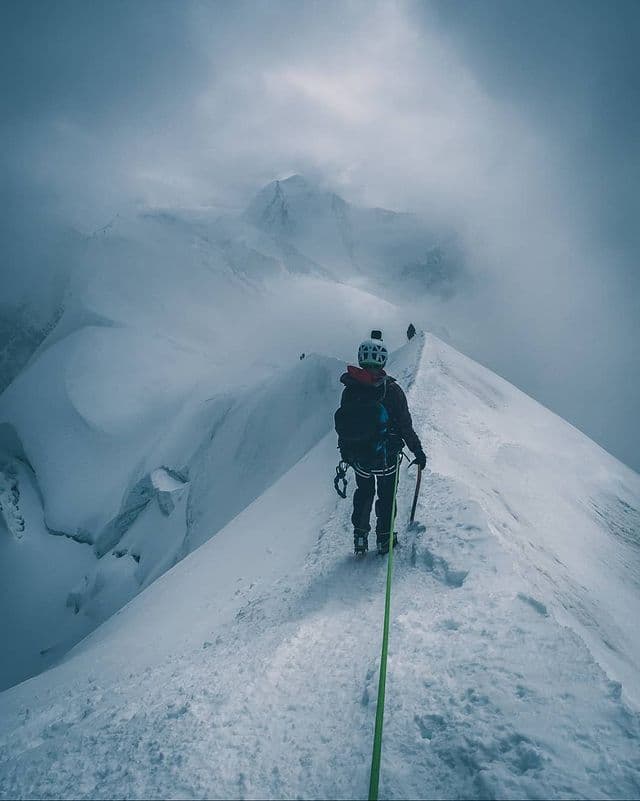 Mountaineering along a snow ridge, roped up