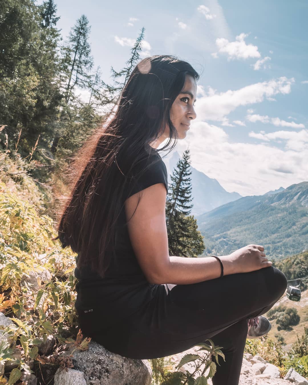 Sitting on a rock overlooking mountains and forest