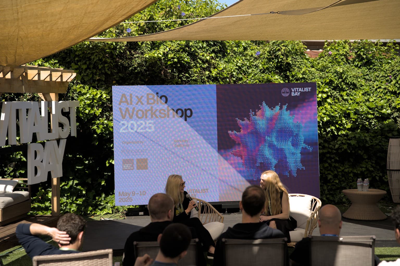 AI × Bio Workshop stage screen, on-site photo